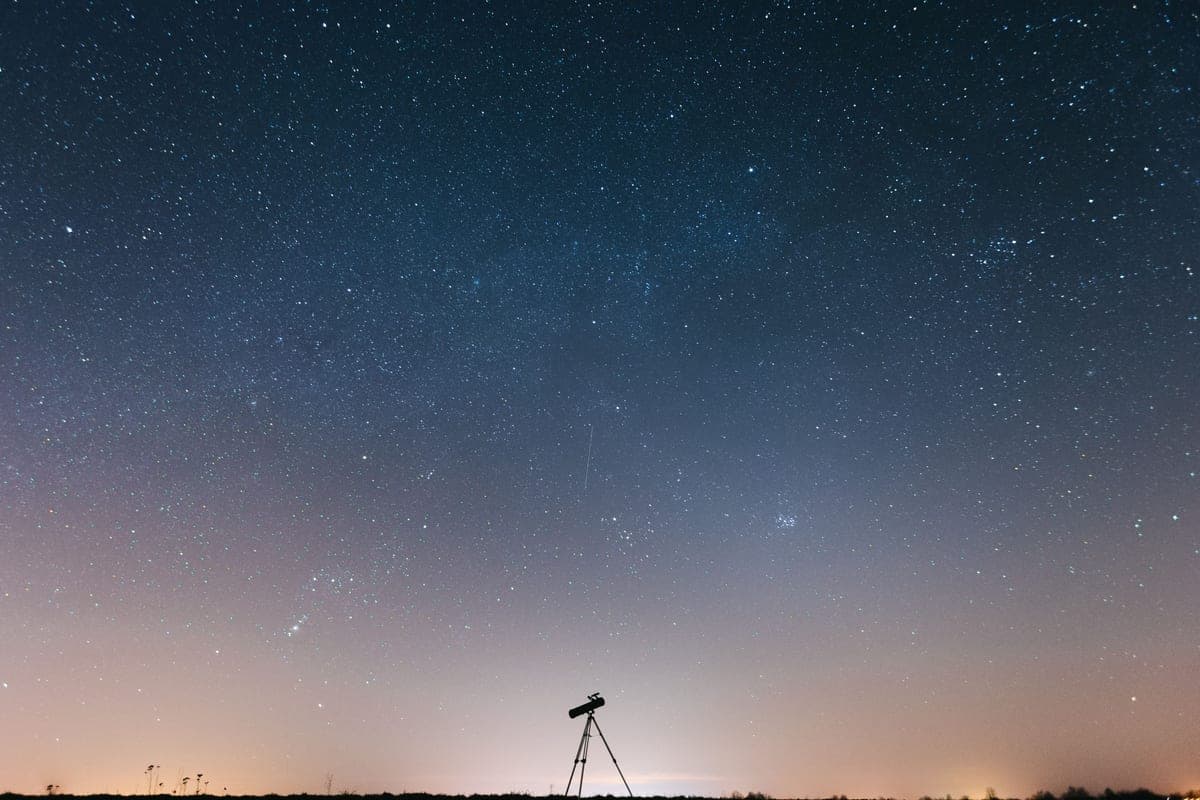 A star-filled night sky above a silhouetted observer