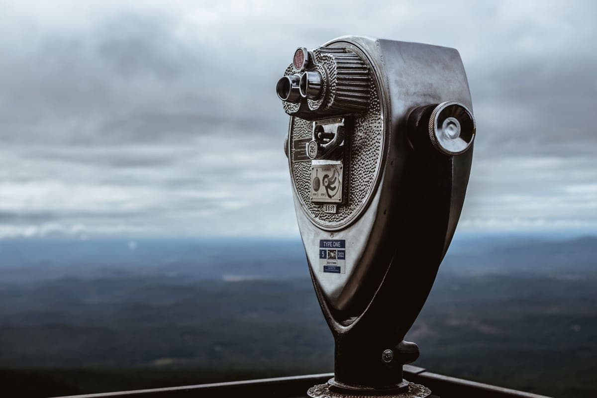 Large binoculars mounted on a tripod under a night sky