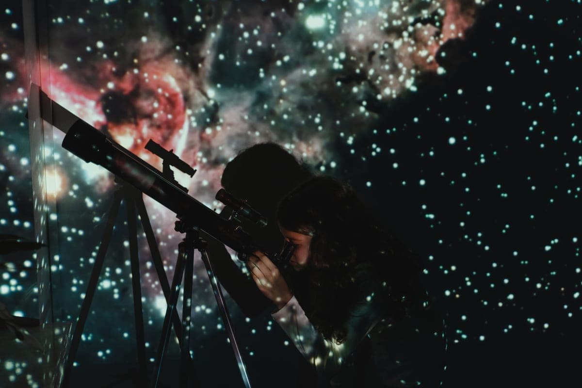 An adult and a child looking up at the night sky together