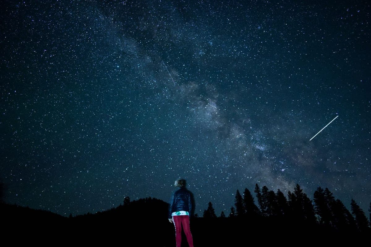 A person silhouetted against the Milky Way on a clear night