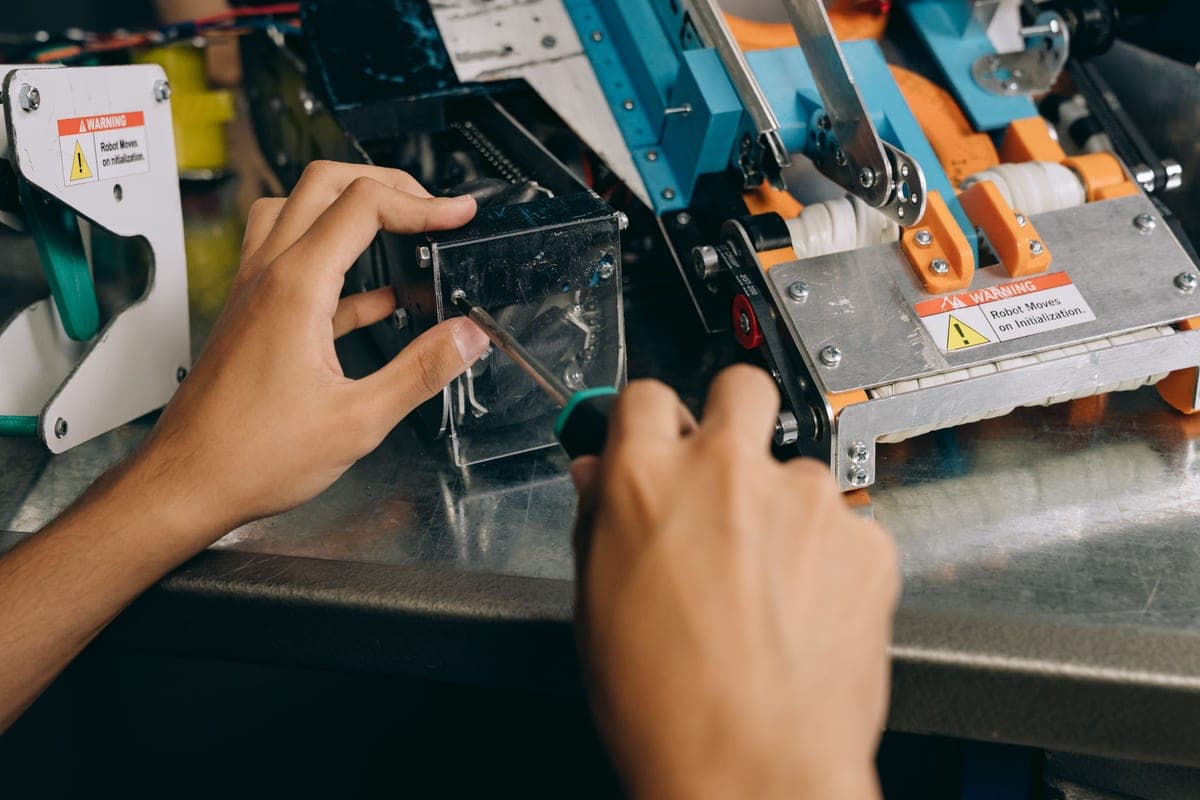 Hands assembling precision equipment with tools on a workbench