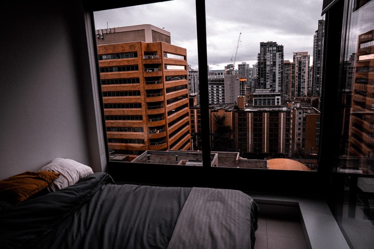 A bedroom window at night with a dark sky beyond it