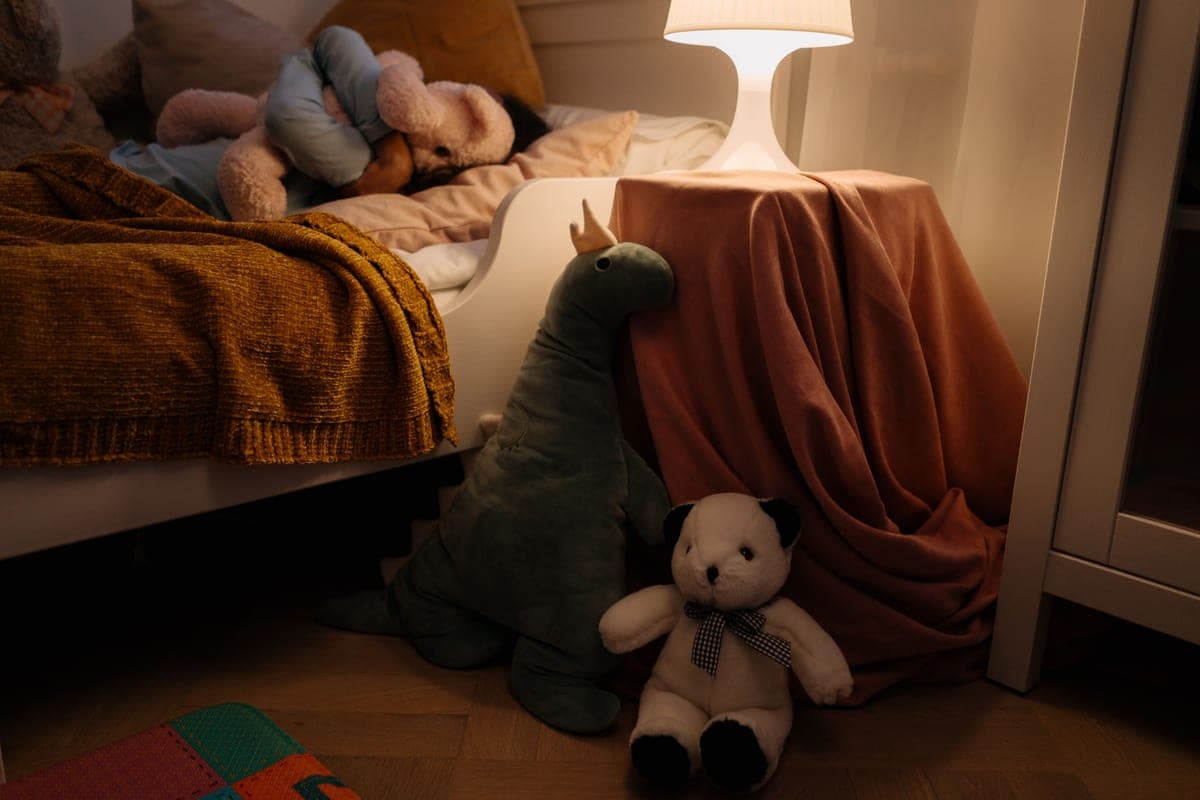 A child's bedroom at night lit by soft colored light